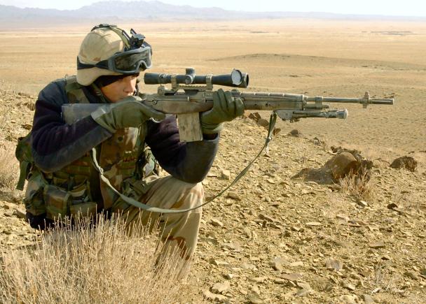 O caçador mira com um rifle. um homem camuflado está se preparando para  atirar. caçando na floresta com um rifle de precisão